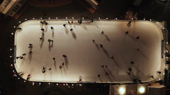 People Are Skating on Ice Rink in the Evening, Aerial Vertical Top-down View alt