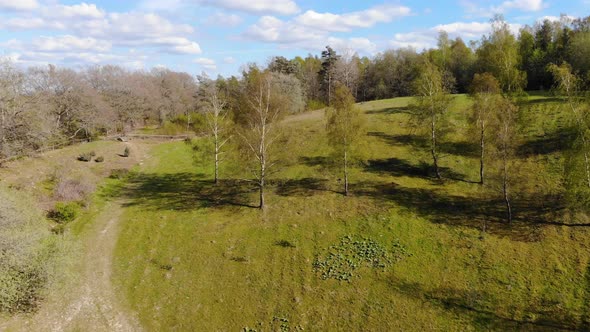 Drone starting of in valley going upwards to get a nice view of forest and fields, Skrylle alt