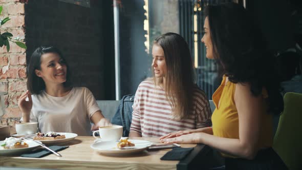 Beautiful Young Woman Joining Hands Together and Laughing in Modern Cafe alt