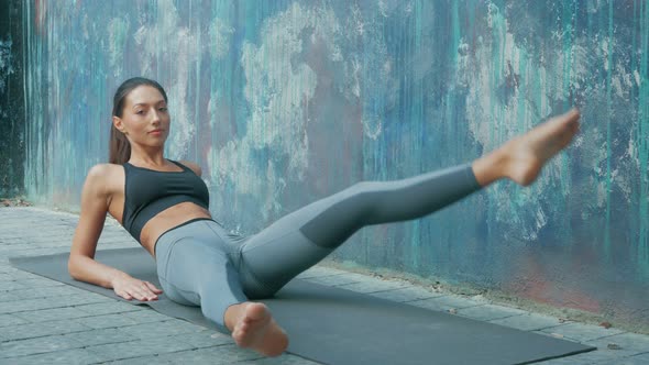 young sportswoman doing abs exercises outdoors