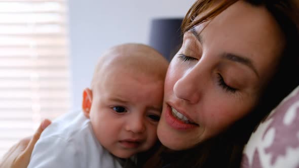 Young mother holding and kissing her baby at home 4k alt