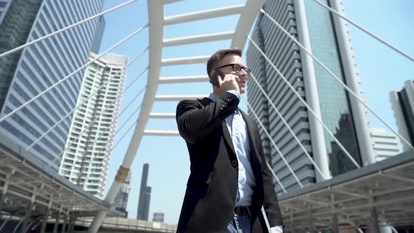 Businessman Talking On Phone At City