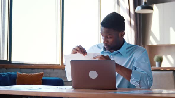 Young man in shirt showing his projects to colleague via video call remotely alt
