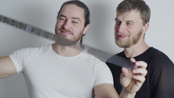 The Guys are Looking at the Film with Interest Remembering Their Childhood Smiling alt