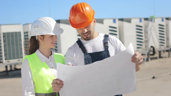 Two Happy Engineers are Discussing Project Drawings alt