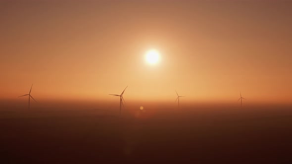 Offshore Windmills Rotate Covered with Heavy Fog at Sunset