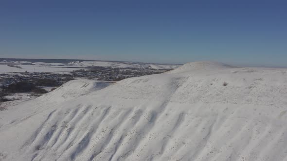 The Village Appears From Behind the Snowy Mountains on a Bright Sunny Day