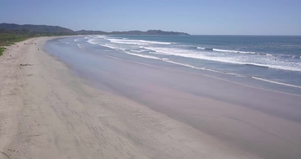 Aerial drone view of the beach, rocks and tide pools in Guiones, Nosara, Costa Rica. alt