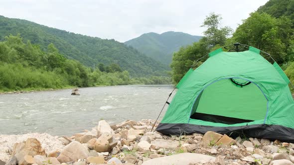 Green Tent on the Rocky Bank of a Mountain River Yukon Tributary Klondike Canada alt
