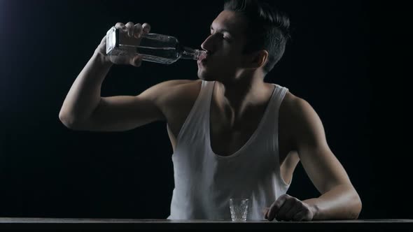 Depressed Man Drinking Vodka in a Dark Room