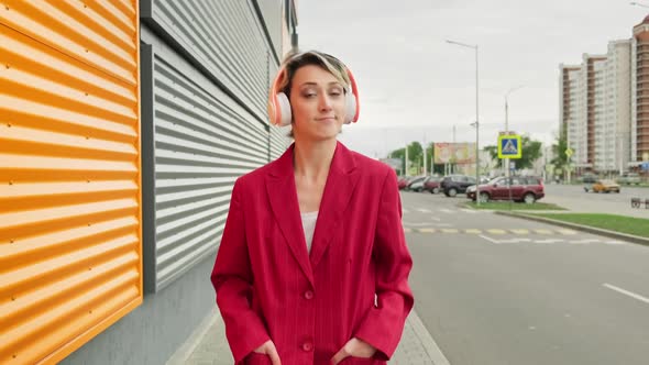 Young Woman Walking at City Street with Headphones alt