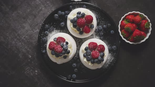 Delicious Mini Pavlova Meringue Desserts Served with Frozen Frosty Berries