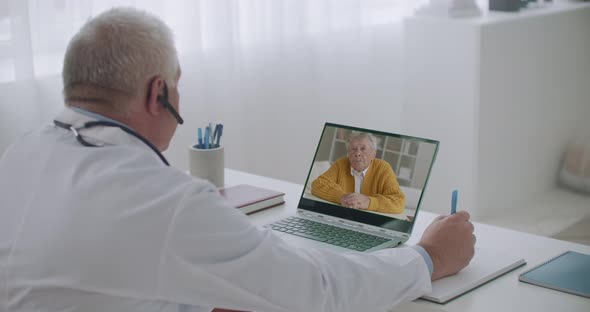Male Doctor Is Asking Elderly Patient at Online Appointment, Remote Consulting of Sick Man alt