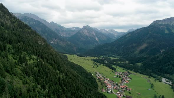 Majestic Aerial View of Village in Alps Mountains. Alpine Countryside with River