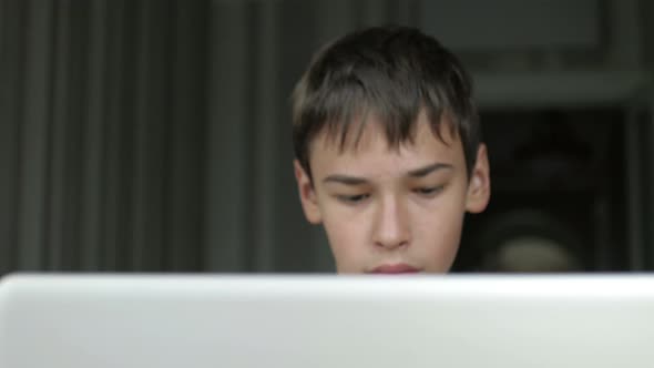 teenager surf the internet for a laptop at home