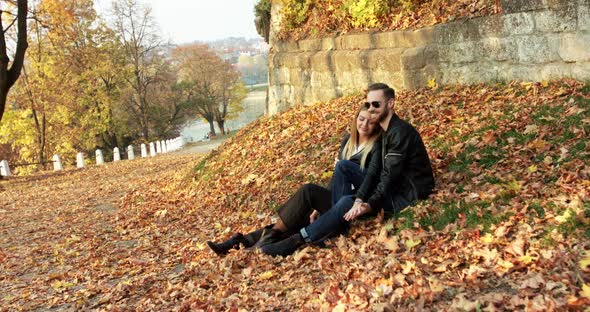 Beautiful Autumn View with Couple in Love Relaxes Caresses Each Other on Lawn alt