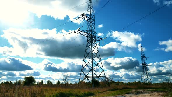 Power Lines And Blue Sky Time Lapse. High Voltage Electricity Transmission Pylon. alt