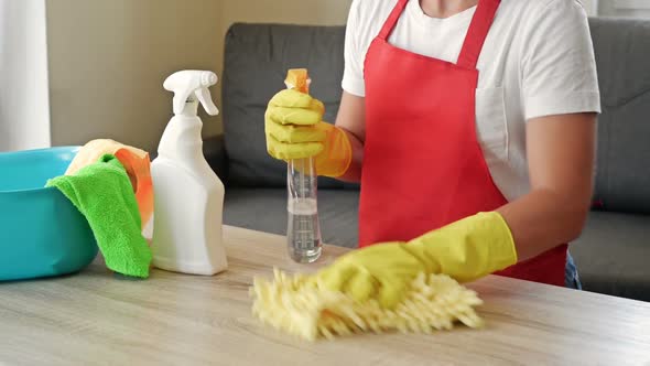 Woman in an Apron and Protective Gloves Washes and Polishes the Countertop Diligently alt