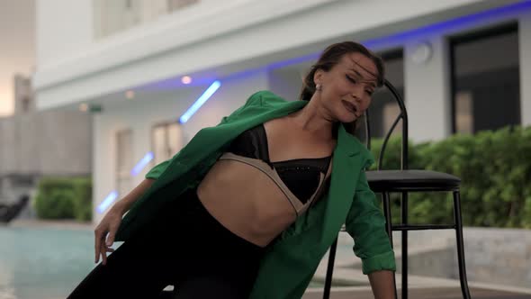 Sensuous Dancer Posing By Chair At Poolside alt