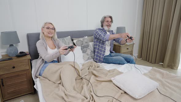Senior Couple Playing Video Games Together While Spending Weekend with Little Granddaughter alt