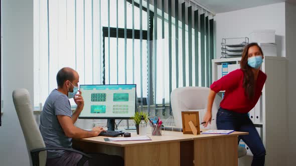 Woman with Mask Helping Colleague alt