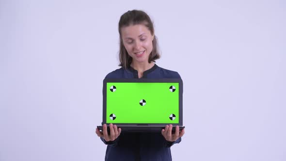 Happy Young Beautiful Businesswoman Talking While Showing Laptop alt