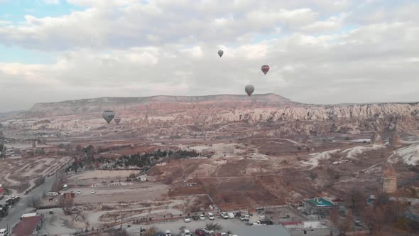 Aerial 4k drone footage of hot air balloons over the desert landscape of Cappadocia, Turkey. alt