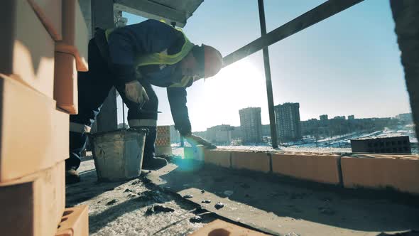 Male Constructor Is Doing Masonry in a Building in Progress alt