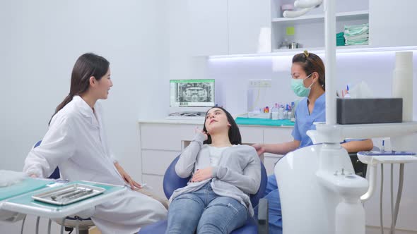 Asian female dentist welcome and recommend dental treatment plan service to young patient on chair. alt