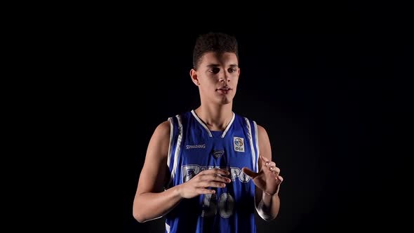 Young African American Guy in Basketball Uniform Posing in Studio on Black Background alt