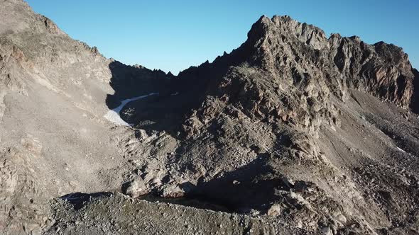 Mountain rocky summit in the alps, Switzerland. blue sky, snow, drone aerial view alt