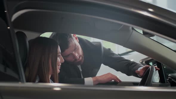 Salesman Shows the Car Features for Client. The Car Is New. Salesman Do the Best To Sell This One. alt