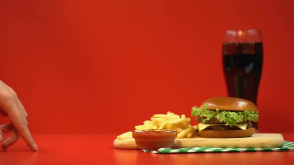 Tiny Female Fingers Walking to French Fries, Taking One, Tempted by Fast Food alt