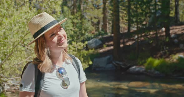 Young Woman Enjoying Sunny Day with Nature and Green Forest on Background alt