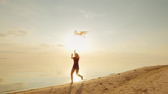 Happy Young Woman Running with a Kite. alt