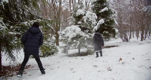 Happy Children Playing Snowballs In A Snowy Park. Happy Winter Vacation