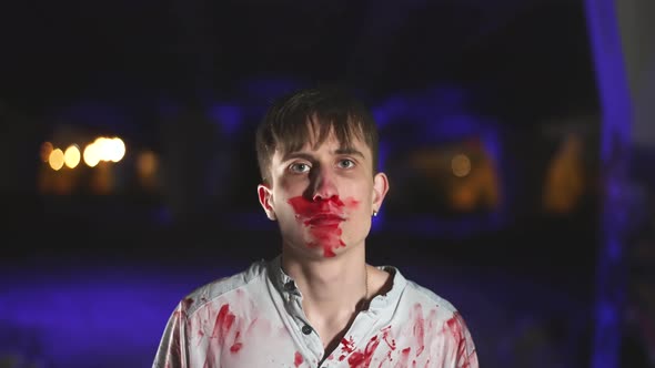Psycho Murderer at Crime Scene with Blood Splatter on Clothes Looks at Camera alt