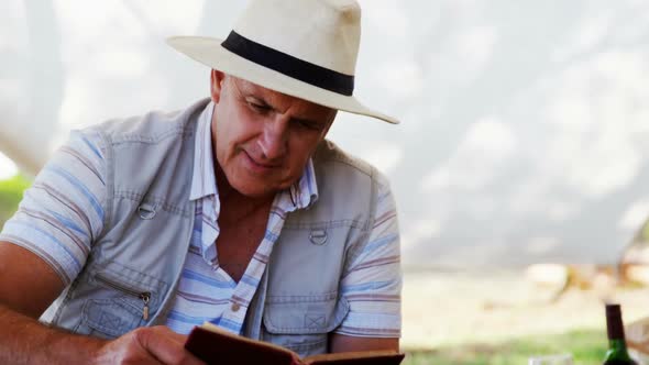 Smiling man reading book in cottage 4k alt