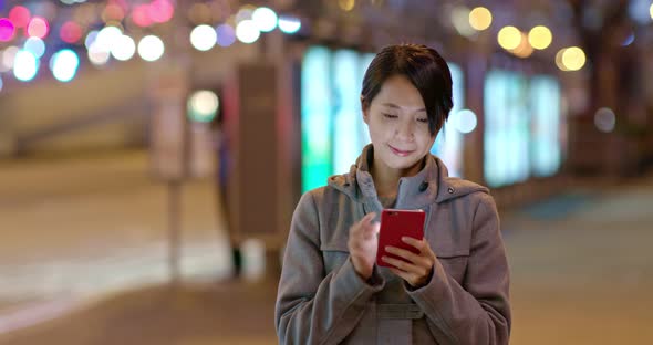 Asian woman use of mobile phone in city at night alt
