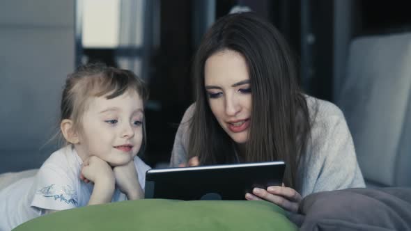 Happy Family Young Mum And Cute Little Kid Daughter Use Digital Tablet Technology Device  alt