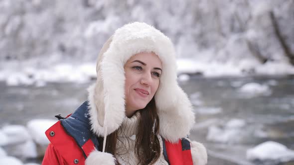 Portrait of Happy Woman on the Banks of a Mountain River in the Winter Forest Enjoying Nature and