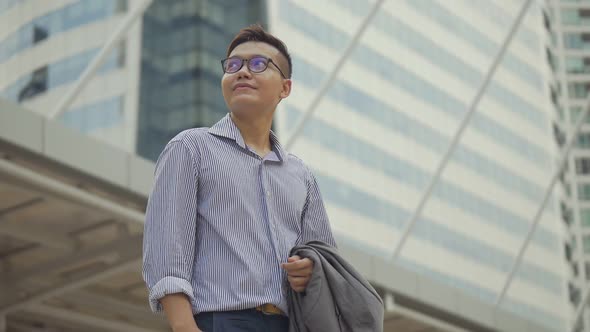 Portrait handsome businessman standing looking around the urban city.