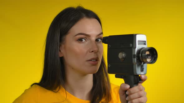 Young Woman Cinematographer is Using a Retro Camcorder for Shooting Video alt