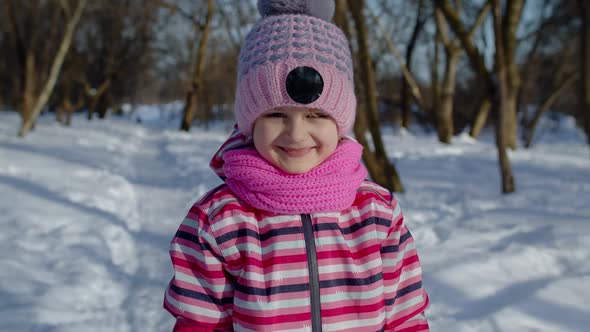 Smiling Child Kid Looking at Camera Showing Tongue Fooling Around Making Faces in Winter Park alt