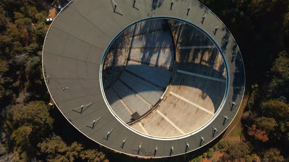 Aerial top down spinning over Quinta Vergara Amphitheater surrunded by tree forest in park, Viña del alt