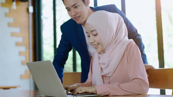 Upwardly mobile Asian Muslim business entrepreneur SME start up group of young man and women, discus alt