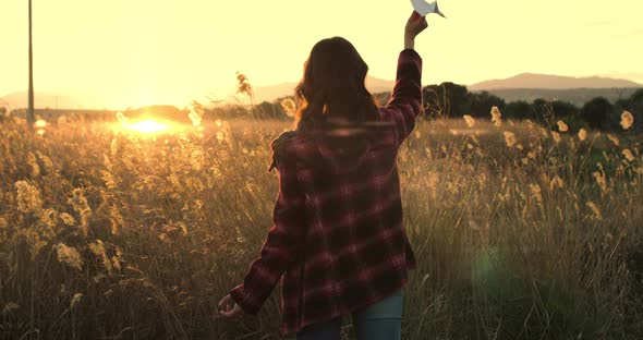 Girl plays with paper plane alt