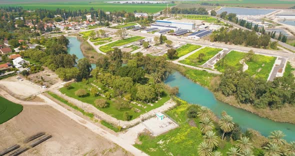 Aerial view of cultivated fields with hills in the background and Kibbutzim. alt