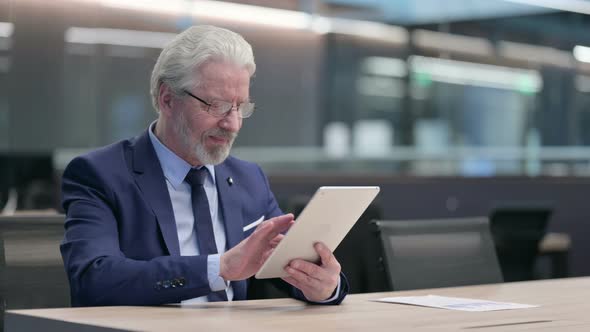 Old Businessman Having Success on Tablet at Work alt