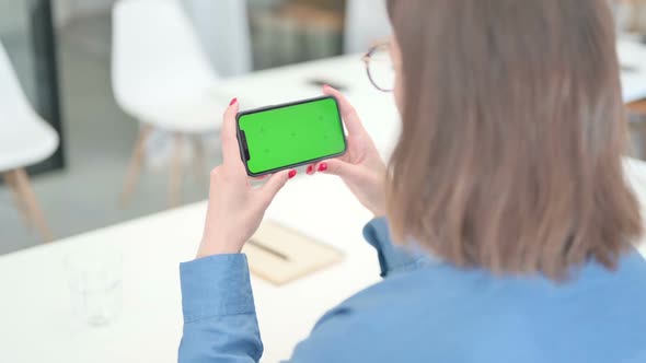 Young Woman Looking at Smartphone with Chroma Screen alt
